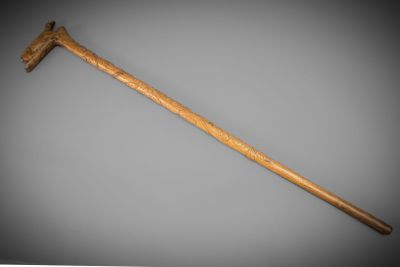 an old wooden hammer with a wooden handle on a gray background