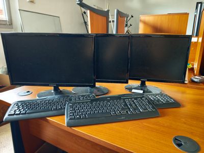 deux écrans d'ordinateur et un clavier sur un bureau