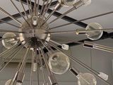 a large chandelier with many light bulbs hanging from it ' s ceiling
