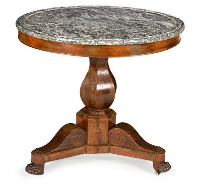 une table ronde avec un plateau en marbre reposant sur un piètement en bois