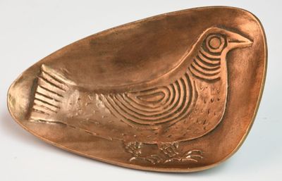 une petite plaque de cuivre sur laquelle est représenté un oiseau