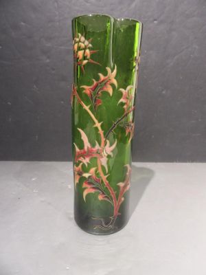 un vase en verre vert orné de fleurs rouges et jaunes