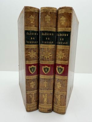 trois vieux livres posés l'un sur l'autre sur une table