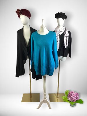 three mannequins wearing different colored clothing on a display stand