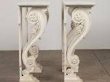 pair of white marble pedestals with carved designs on top of them