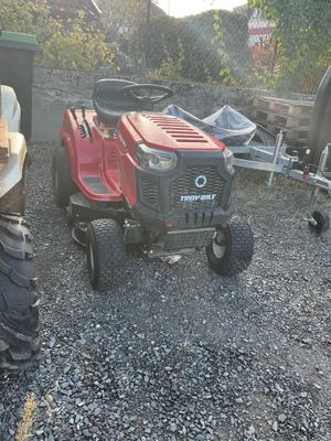 une tondeuse à gazon garée à côté d'un tracteur