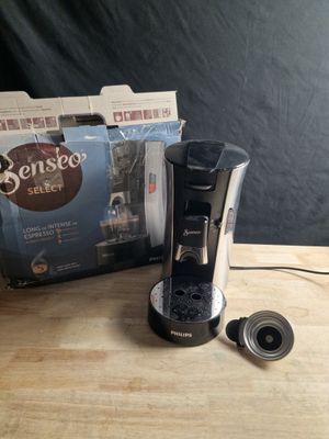 une cafetière posée sur une table à côté d'une boîte de café