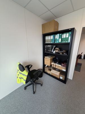 une photo d'une pièce avec une chaise et une bibliothèque