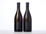 two bottles of wine sitting on top of a table next to each other