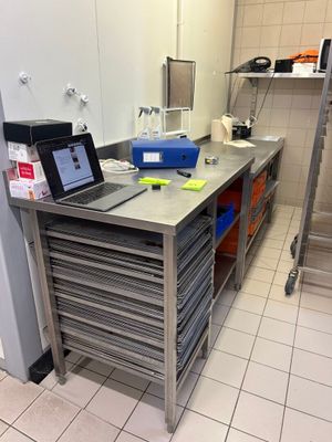un ordinateur portable posé sur une table en métal dans une cuisine