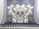a blue and white blanket with a skull and flowers on it
