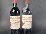 two bottles of red wine sitting next to each other on a table