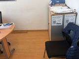 un bureau avec une chaise et un réfrigérateur dans un coin