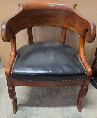 un fauteuil en cuir noir avec une structure en bois et une assise en cuir noir