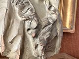 a bust of a woman on a table with a painting in the background