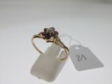 a close up of a gold ring with a purple stone