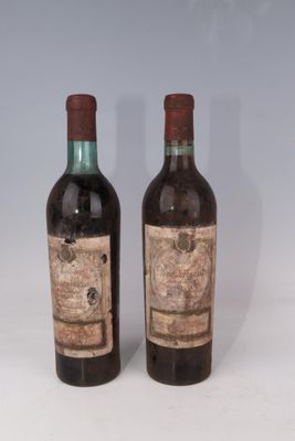 deux bouteilles de vin posées l'une à côté de l'autre sur une surface blanche