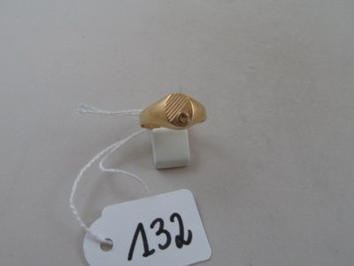 a white tag with a gold shell attached to it