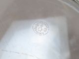 a close up view of a silver plate with a stamp on it