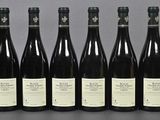 six bottles of wine are lined up in a row on a table