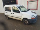 une petite camionnette blanche garée devant un bâtiment