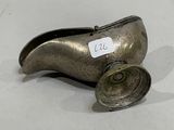 a silver shoe with a tag on it sitting on a table