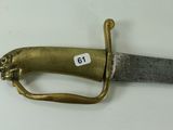 a very old knife with a gold handle on a white table