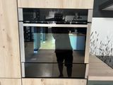 une personne debout devant un four dans une cuisine