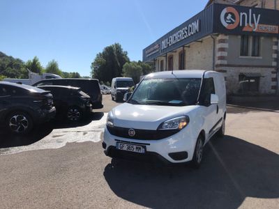 the small white van is parked in front of a building