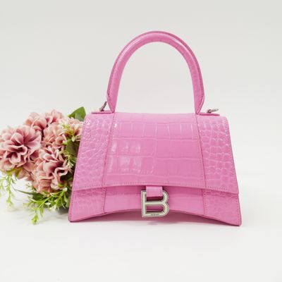 a pink handbag with a flower on a white background