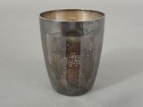 a silver cup with a design on it on a table