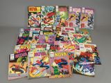 many comic books are stacked on top of each other on a table