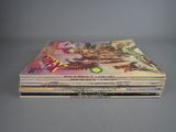 several comics are stacked on top of each other on a table