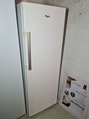 un réfrigérateur blanc posé contre un mur blanc