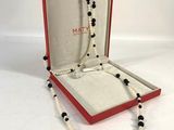 Ensemble composé d'un collier et d'un bracelet en perles noires et blanches, présenté dans un coffret rouge