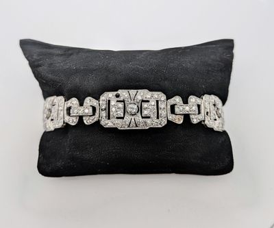 un bracelet en or blanc et diamants posé sur un coussin noir