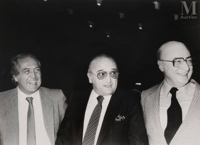 photographie en noir et blanc de trois hommes en costume et cravate, debout côte à côte