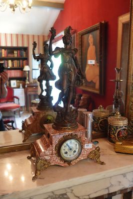 une horloge posée sur une table dans une pièce aux murs rouges