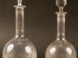 trois bouteilles en verre posées sur une table, sur fond noir