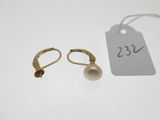 a pair of gold earrings with pearls and a price tag
