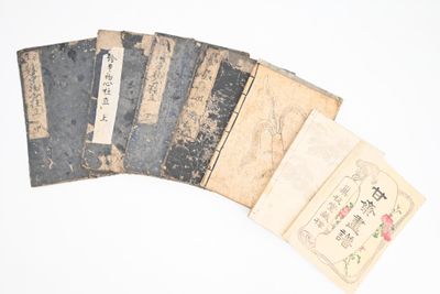 cinq vieux livres portant des inscriptions en chinois sur une surface blanche