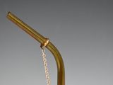 a gold metal drinking straw with a chain attached to it