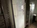 a refrigerator in a bathroom with a lot of magnets on the door