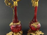 pair of antique red and gold vases on stand on black background