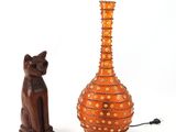 un chat et un vase posés l'un à côté de l'autre sur une table