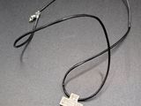 a necklace with a cross on it sitting on top of a table