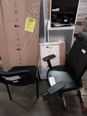 une chaise de bureau noire posée à côté d'une pile de cartons