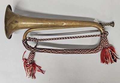 une vieille trompette en laiton à laquelle est suspendue une chaîne par l'embouchure