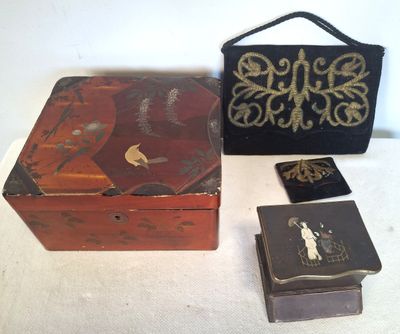 Trois petites boîtes en bois et un sac à main sont posés sur une table