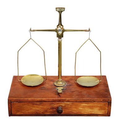 une vieille balance en laiton surmontée d'une boîte en bois